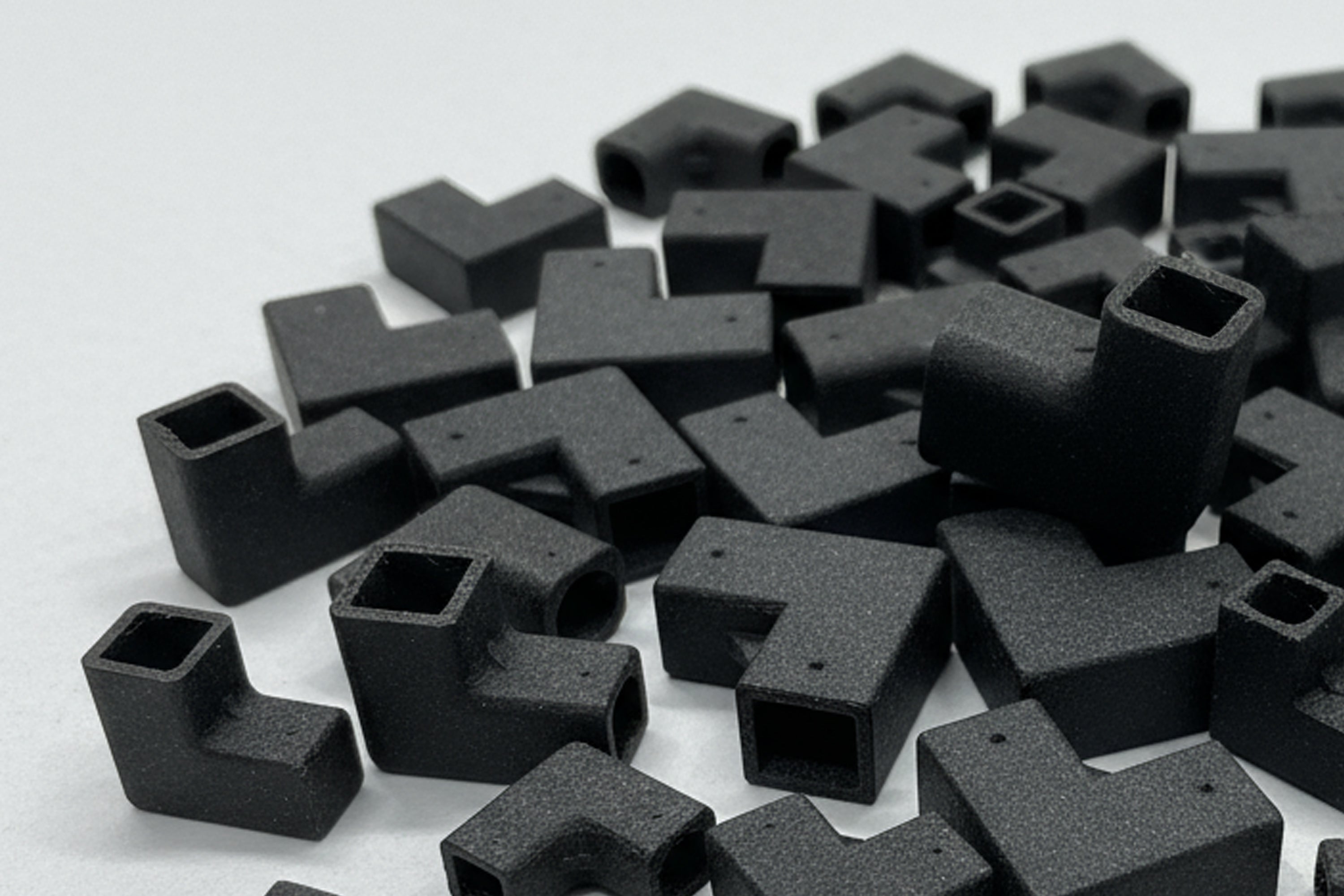 Collection of black L-shaped brackets on a white background