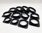 A set of ten black plastic circular ring-shaped components with square mounting flanges, arranged on a light gray background.